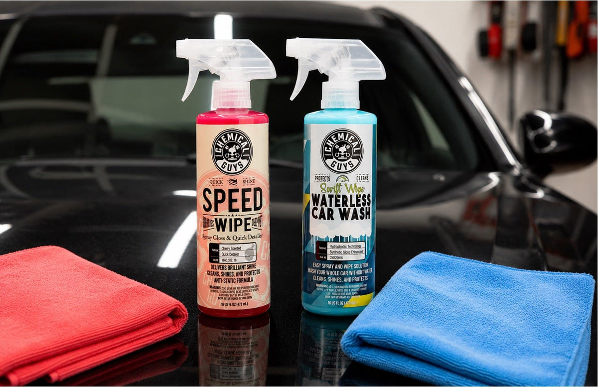 Two bottles of Chemical Guys Speed Wipe and Waterless Car Wash sitting on the hood of a car next to some microfiber towels